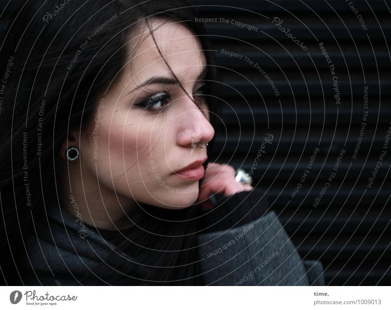 . Feminine Young woman Youth (Young adults) 1 Human being Wall (barrier) Wall (building) Coat Piercing Black-haired Long-haired Observe Rotate Looking Dark
