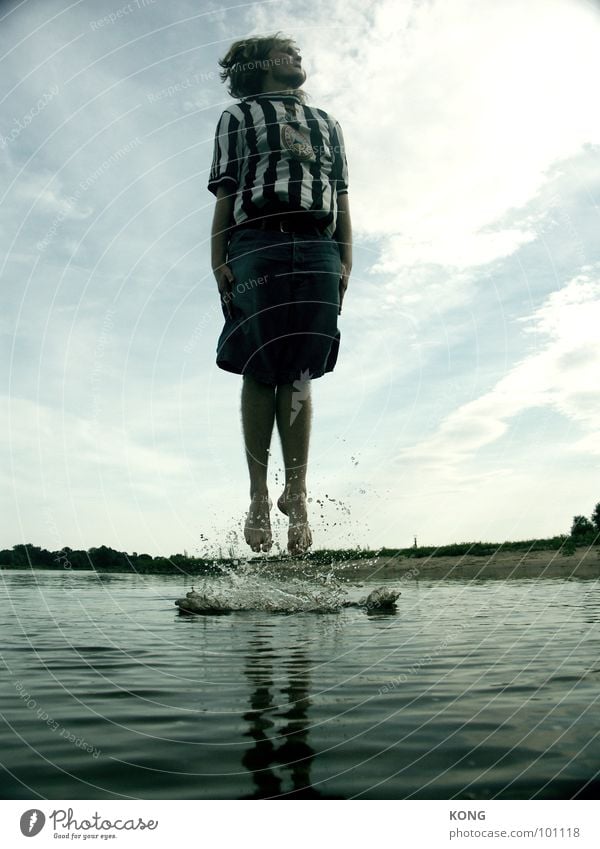 water birth Jump Beach Jersey Waves Surface of water Clouds Young man Man Joy Playing Water Inject Drops of water go up in the air Flying Tall Upward Dynamics