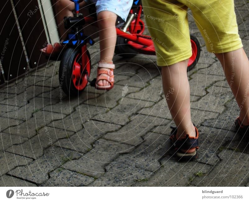 Watch The Children Play Playing Tricycle Driving Red Tread Sandal Stand Kick about Pants Shirt Yellow Footwear Summer Communicate bycicle Seating Sit Wheel