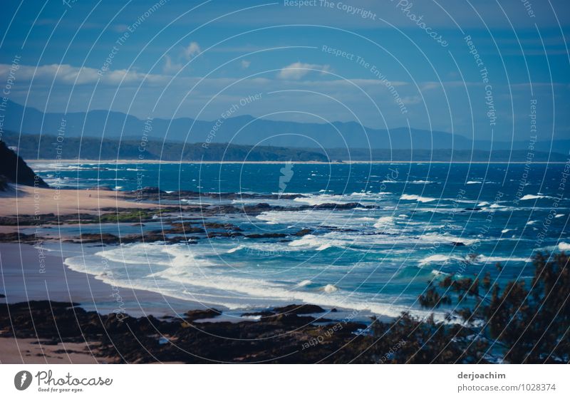 Foaming surf on rocky coast, blue sky, clouds and high mountains in the background, Queensland / Australia . ,Lookout Joy Harmonious Vacation & Travel Beach