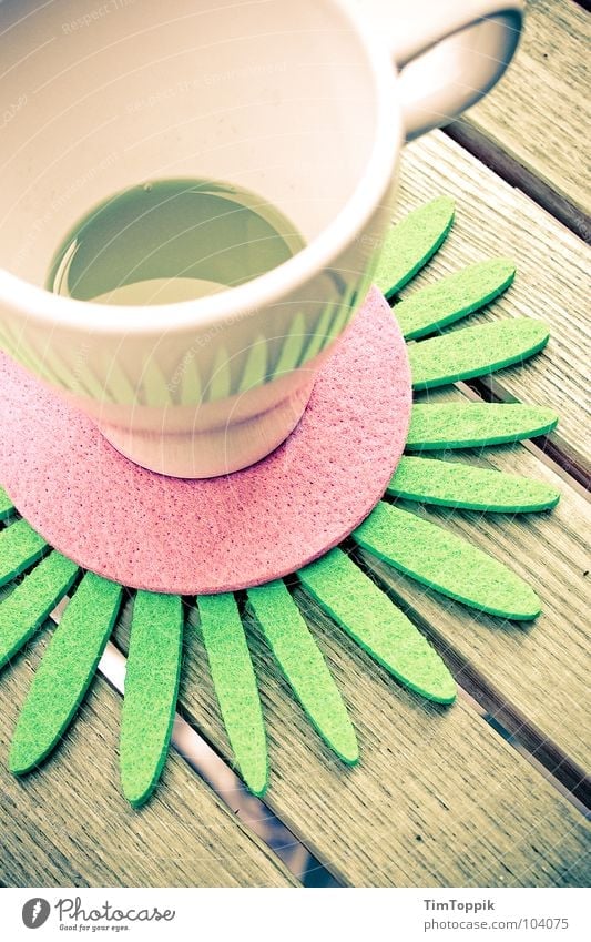 Slightly stocky Cup Café Coffee cup Table Coaster Carry handle Orange juice Wooden table Drinking To enjoy Summer Bleached Balcony Felt Pink Green Gastronomy