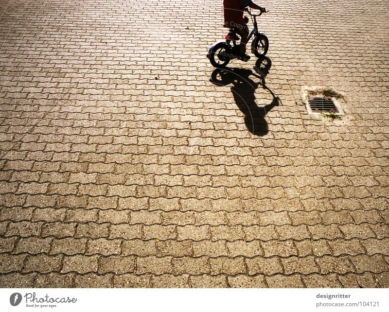 Trial and ... Bicycle Driving Cycling Kiddy bike Child Cobblestones Pedestrian precinct Practice Beginning Playing Wheel Shadow Boy (child) Street