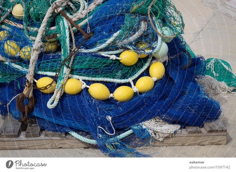 rope team  colourful fishing nets with thick coloured ropes and fishing  balls lie on quay wall - a Royalty Free Stock Photo from Photocase