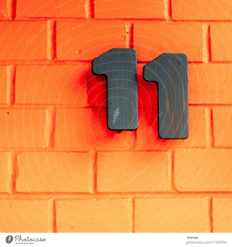 11 Style Wall (barrier) Wall (building) Brick wall Digits and numbers Orange Black Colour Age schnapps number House number Colour photo Exterior shot Close-up