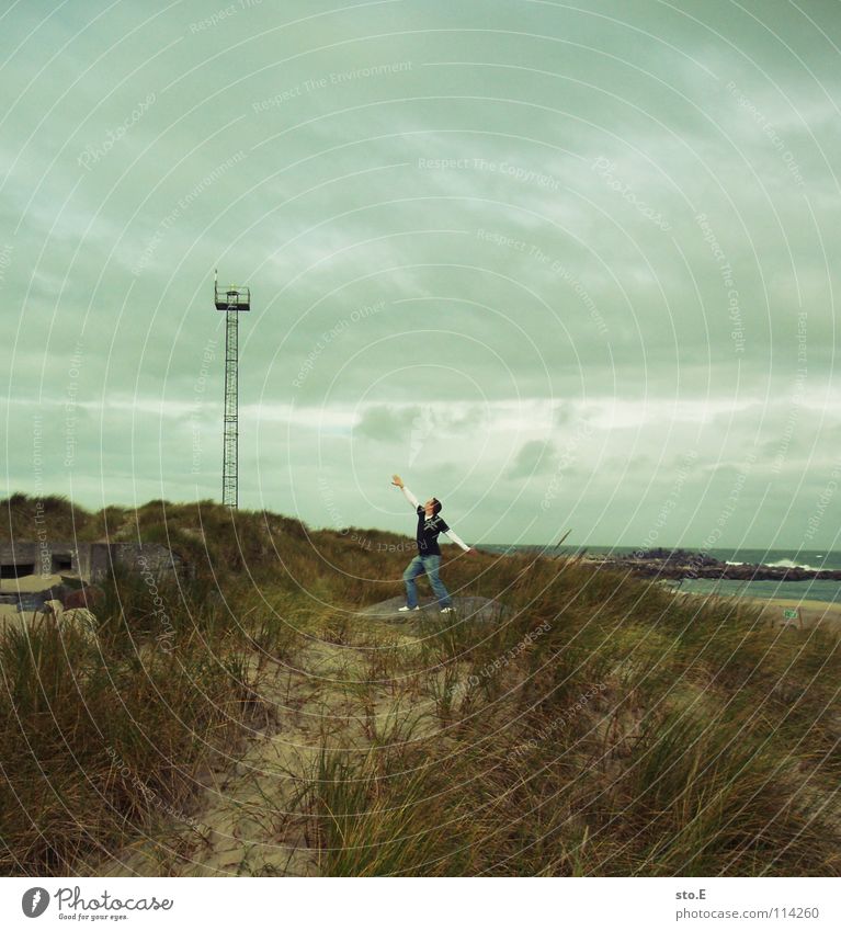 photo search title Fellow Man Posture Beach Ocean Lake Surf Broadcasting tower Stand Direction Clouds Bad weather Blown away Wind Footbridge Gale