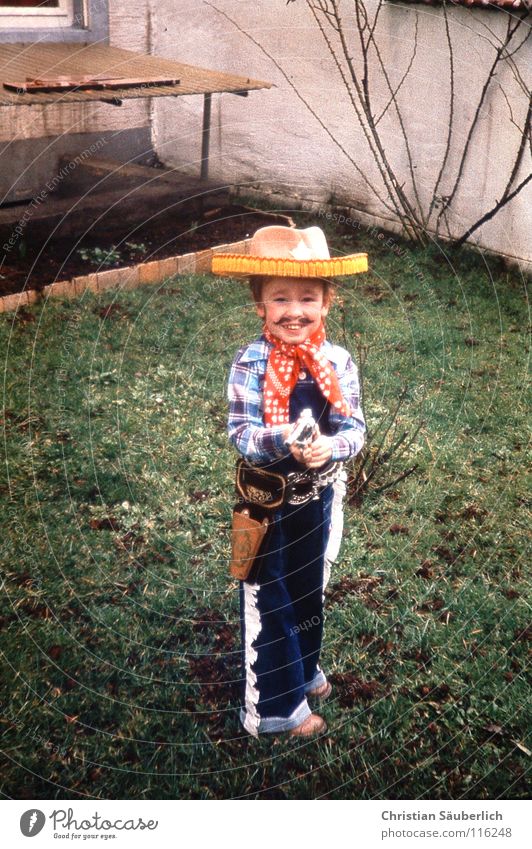 Young Gun Cowboy Cowboy hat Carnival Ahoy Moustache Happiness Child Grass Green Weapon Image type and genre Western Handgun Toddler Hero Helau alaaf Laughter