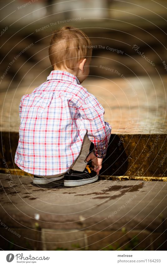 concentrated Toddler Boy (child) Infancy Body Head Back Arm Fingers Legs Feet 1 Human being 1 - 3 years Water Spring Shirt Jeans Sneakers Fountain Observe