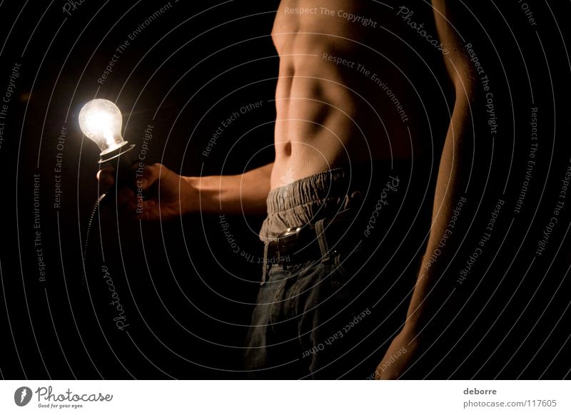 Young man posing topless in the dark with lightbulb. Close-up Electric bulb Fellow Light Naked Black Man Arm poor Stomach Legs belly Dude Guy Skin Jeans nude