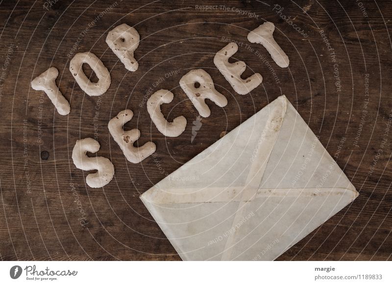 The letters TOP SECRET with an envelope on a rustic wooden table Examinations and Tests Office work Workplace Economy Industry Services Media industry