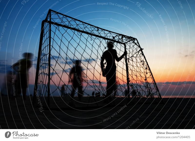 Boys play football at the gate on the summer beach at sunset Lifestyle Joy Playing Summer Sun Beach Ocean Sports Soccer Boy (child) Man Adults 18 - 30 years