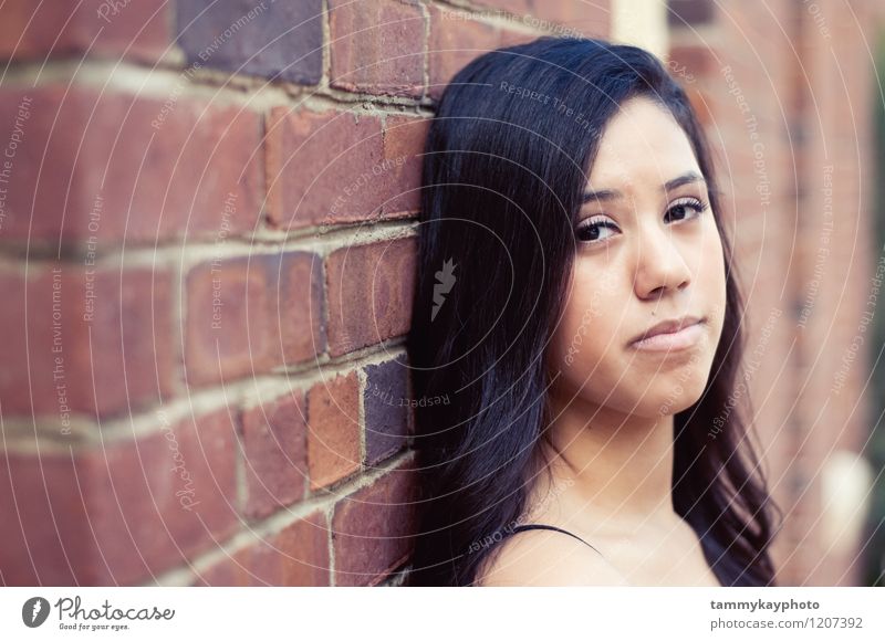 Pretty teen girl leaning on brick wall Human being Young woman Youth (Young adults) 1 18 - 30 years Adults Looking Gloomy Emotions Moody Beautiful Sadness