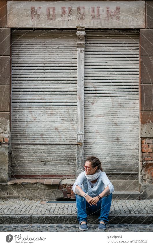 Young woman sitting on sidewalk in front of abandoned house Human being Feminine Woman Adults Life 1 Subculture Village Small Town Old town Facade