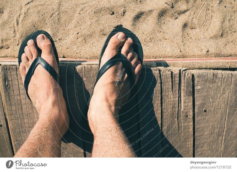 Foto de Young girl legs and flip-flop on the sand beach in summer