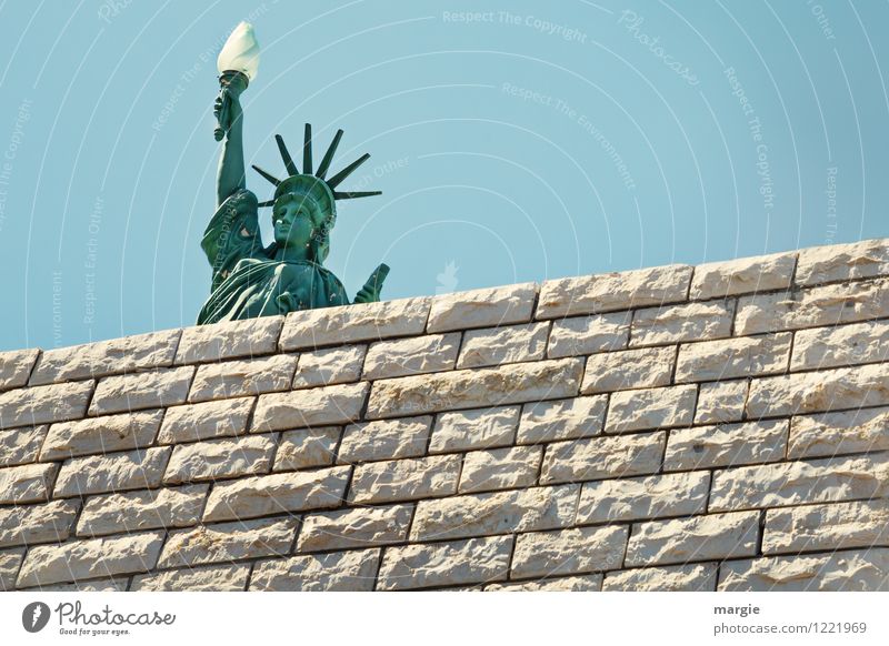 A model of the Statue of Liberty behind a wall Vacation & Travel Tourism Far-off places Freedom Sightseeing City trip Work of art Sculpture Manmade structures