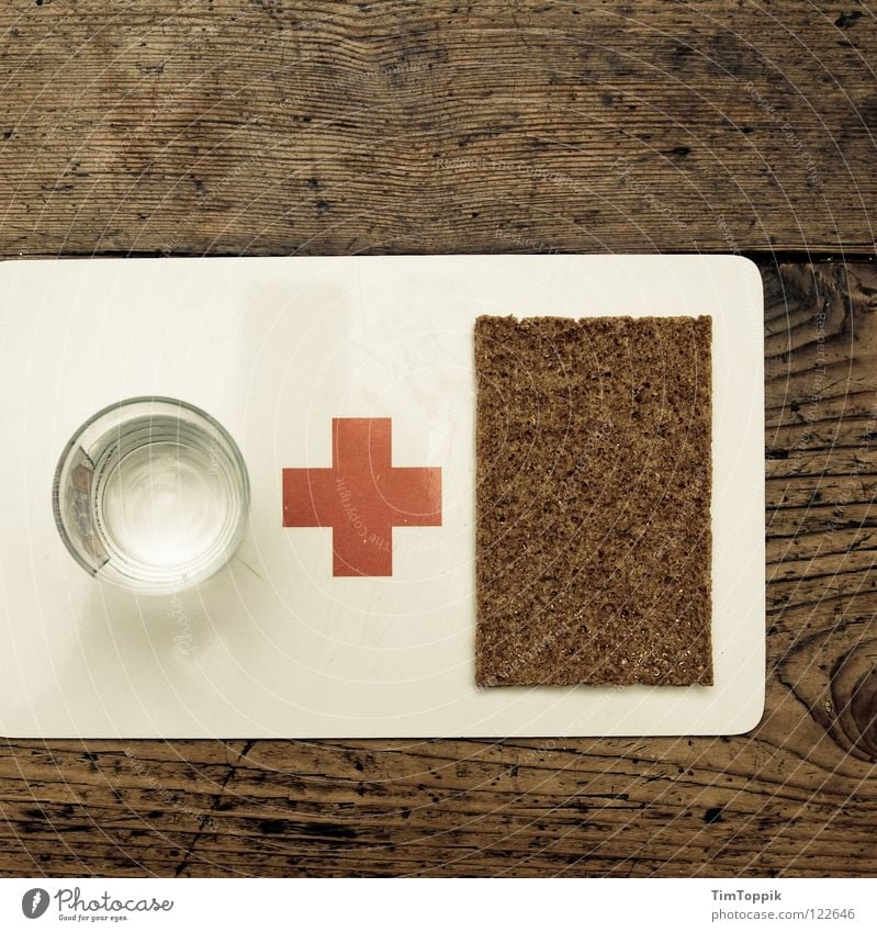 Water & Bread Crucifix Table Texture of wood First Aid Red Dish towel Kitchen Crispbread Black bread Chopping board Appetite Drinking Glass Tumbler Help Poverty