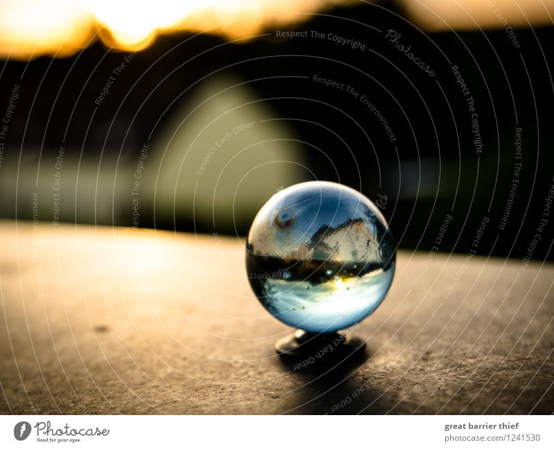 What do you see in the glass ball? Glass Blue Brown Multicoloured Yellow Orange Red Black Marble Glass ball Balcony Colour photo Exterior shot Close-up