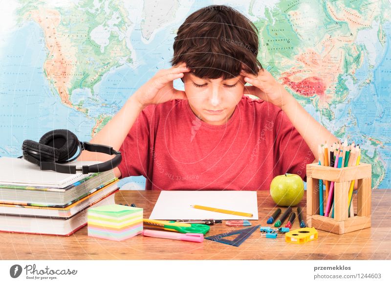 Young boy thinking about his homework Apple Desk Education Study Schoolchild University & College student Workplace Tool Human being Boy (child) 1 8 - 13 years
