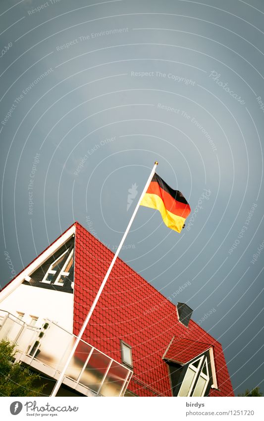 Germany flag on flagpole in front of new family house in Germany. Crooked German Flag House (Residential Structure) Storm clouds Wind Patriotism New building