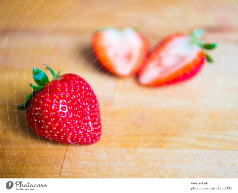 Strawberry on a wooden board Fruit Nutrition Organic produce Vegetarian diet Healthy Eating Summer Fresh Juicy Sweet Green Red background Berries blured cutted