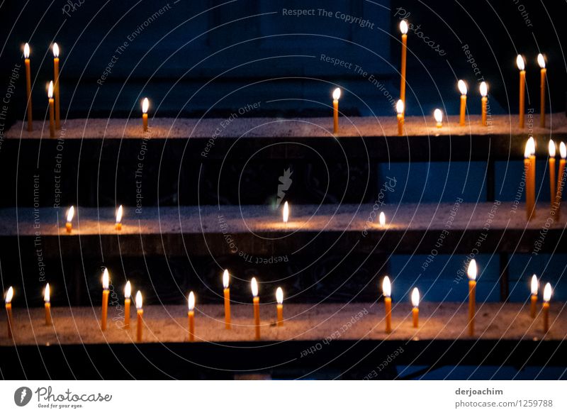 Theme day: diverse/candlelight, candle offering in a church. Many candles are placed on a staircase. With dark background. Exotic Meditation Trip