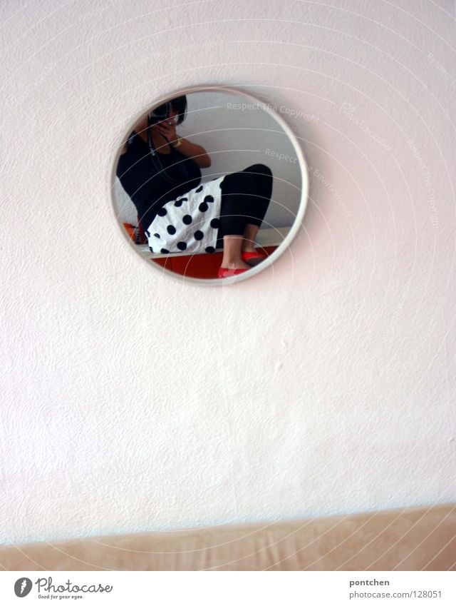 Fashion Young woman in a skirt with dots photographs herself in the mirror. Apartment Mirror Round Living room Mirror image Wall (building) White Clothing Style
