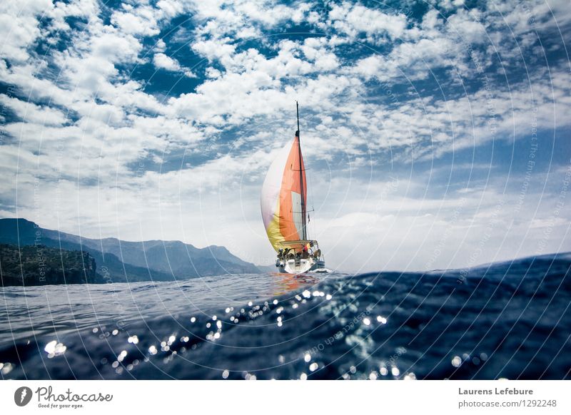 sailboat with colourful sail. Shot from inside the water. Earth Sky Clouds Summer Beautiful weather Ocean Mediterranean sea Creativity Sailing Sailing ship