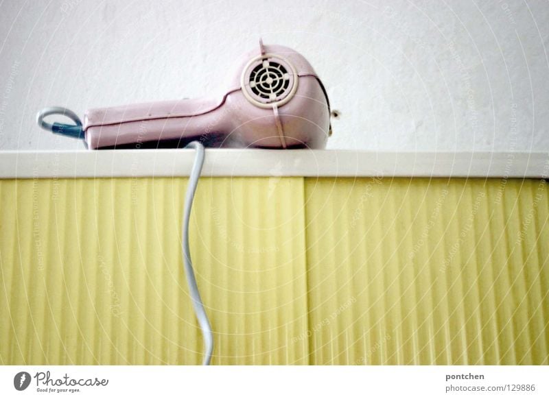Pastels. A pink hairdryer from the 50s is lying on a yellow bathroom cabinet. Vintage, rockabilly. Style Design Hair and hairstyles Contentment