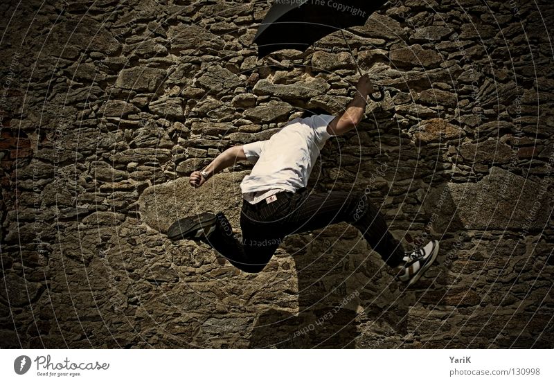 up and away Jump Umbrella Man T-shirt White Black Brown Stony Wall (building) Wall (barrier) Stone wall Plaster Drop shadow Happiness Cheerful
