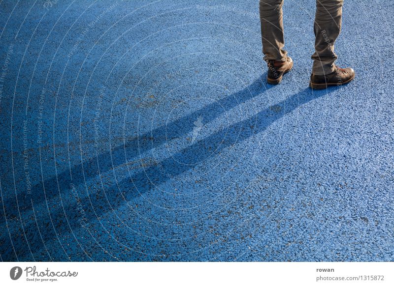 stand Human being Masculine 1 Stand Wait Shadow Asphalt Blue Boredom Colour photo Exterior shot Copy Space left Copy Space bottom Copy Space middle Day