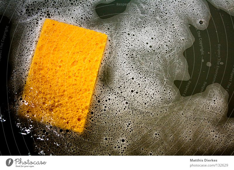 Stack kitchen sponges on yellow table background. Cleaning sponge