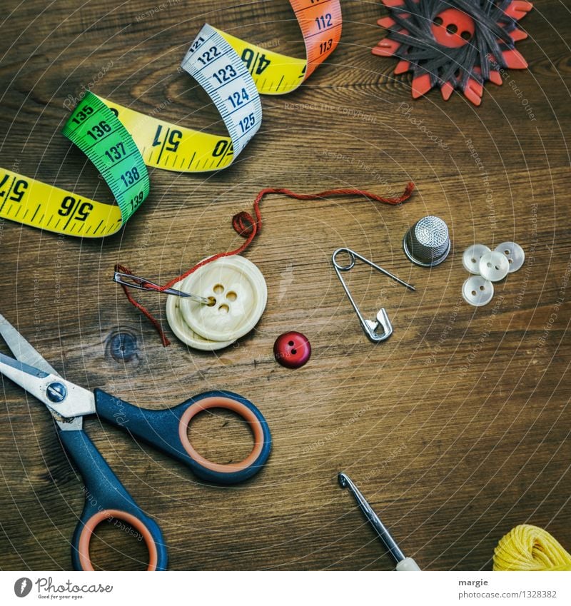 Tape measure, sewing needle and thimble against white background