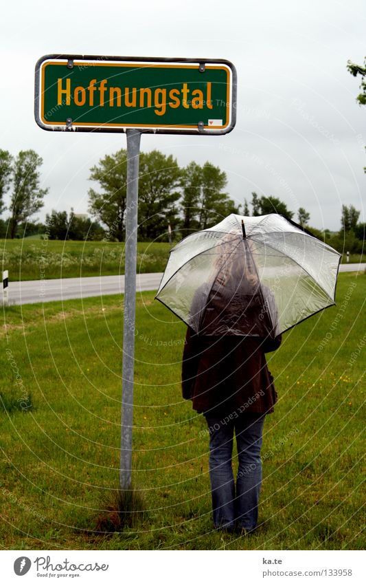 there is HOPE Hope Umbrella Town sign Green Exterior shot Woman Transparent Grass Roadside Tree Gray clouds Gloomy Wet Grief Deities Stand Stagnating Trust