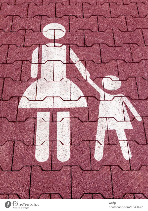 Mother with child symbol in red white on a parking lot Kindergarten Child Parents Adults Red White Symbols and metaphors Parking lot Asphalt Child-friendly