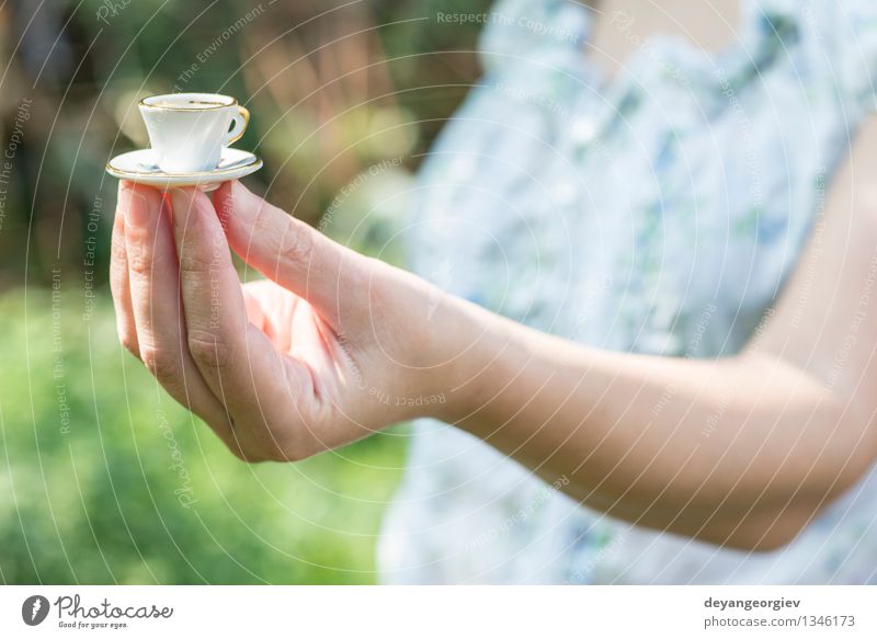 Hand hold very small cup of coffee. Coffee Style Garden Table Woman Adults Old Hot Small Retro White Colour Miniature Café Hold overhead vintage Saucer people