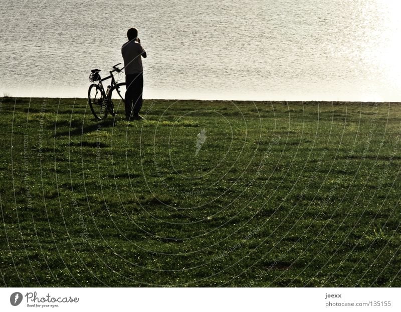 ponder Loneliness Bicycle Cycling tour Think Man Break Calm Lake Sunset Meadow Peace decision making Peaceful crisis meditative Human being Nature Lawn Looking