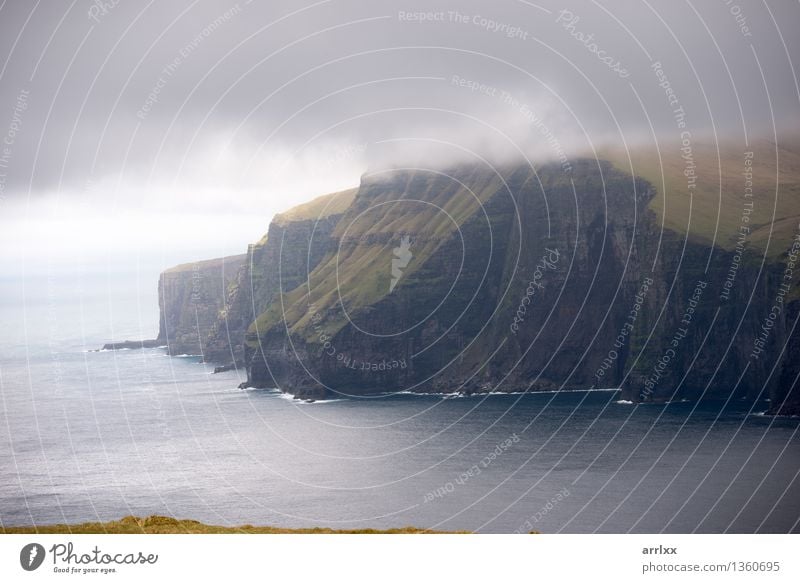 Landscape on the Faroe Islands Beautiful Ocean Mountain Environment Nature Clouds Weather Grass Meadow Rock Stone Gray Green Adventure Freedom intense Dramatic