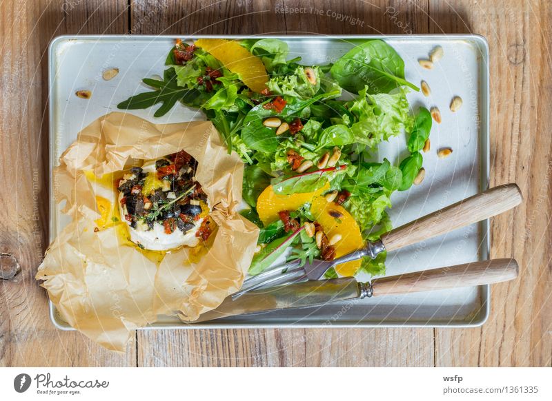 Mediterranean goat cheese baked in parchment paper Vegetarian diet Wood Warmth Goat`s cheese Feta cheese Cooking Pine nut Wooden table Country house Rustic