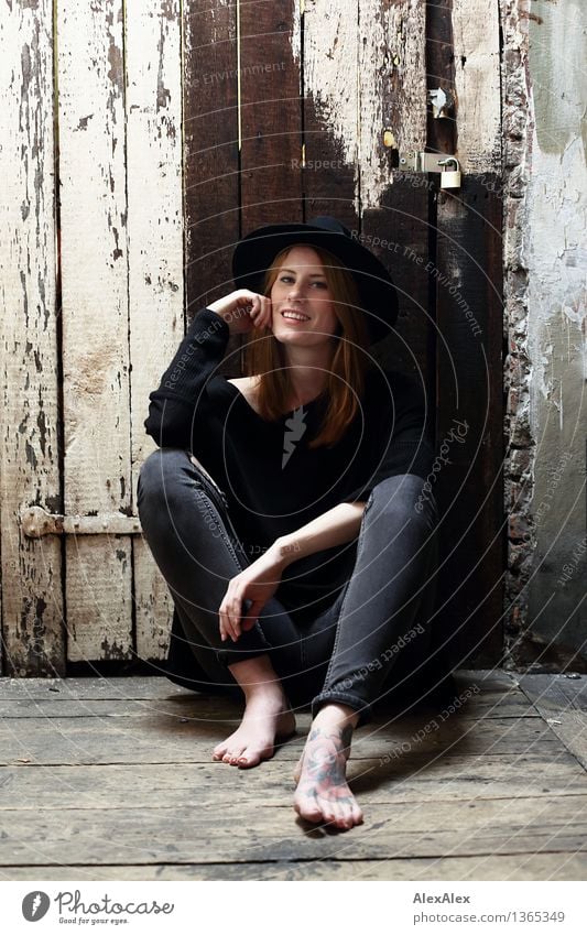 nonchalantly Lifestyle Style Beautiful Young woman Youth (Young adults) Body Feet Barefoot Model Attic Wooden door Wooden wall Jeans Hat Red-haired Long-haired