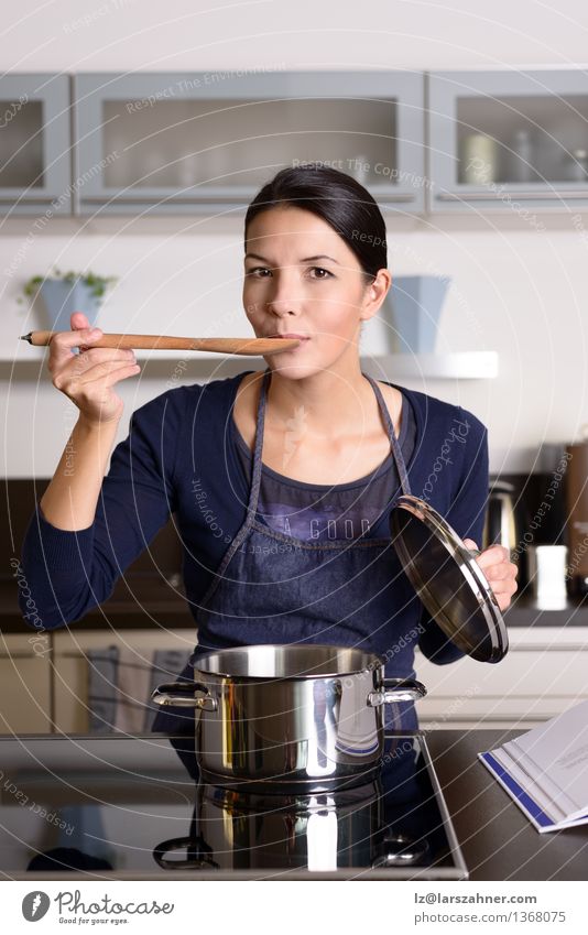 Young housewife tasting her cooking Dinner Pot Spoon Lifestyle Face Kitchen Cook Woman Adults 1 Human being 30 - 45 years Smiling Happy Testing & Control Food