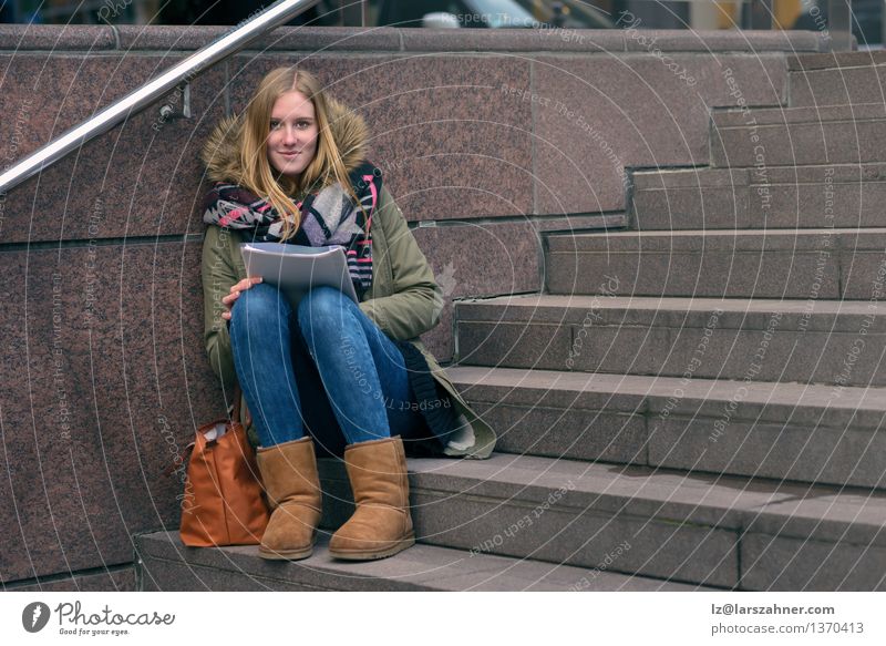 Young woman sitting reading on urban steps Lifestyle Face Relaxation Reading Winter School Study Academic studies Girl Woman Adults 1 Human being 13 - 18 years