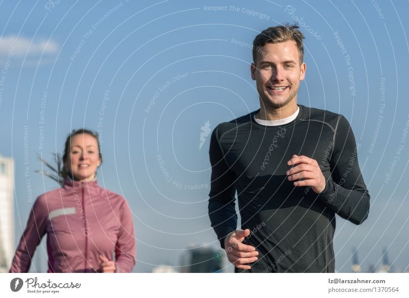 Smiling handsome man jogging with his wife Lifestyle Happy Face Relaxation Sports Jogging Woman Adults Man Friendship Couple 2 Human being 18 - 30 years