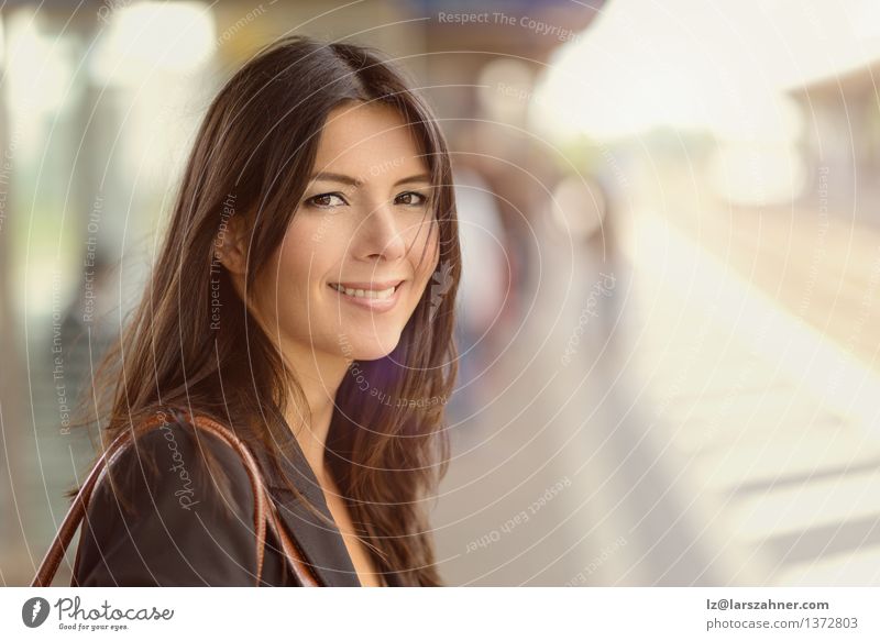Woman with brunette hair smiles at the camera Happy Face Adults Railroad Brunette Smiling Wait background Commuter Swing Copy Space Eco-friendly Middle-aged