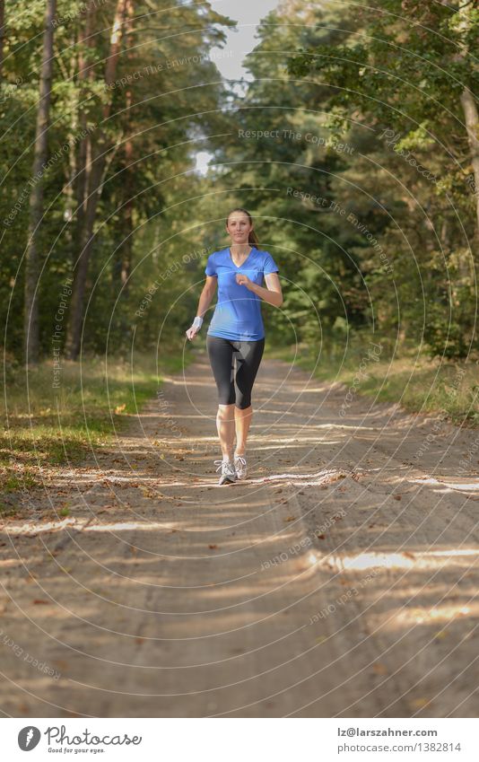 Athletic woman out jogging in a forest Lifestyle Body Sports Jogging Girl Woman Adults 1 Human being 18 - 30 years Youth (Young adults) Nature Landscape Sand