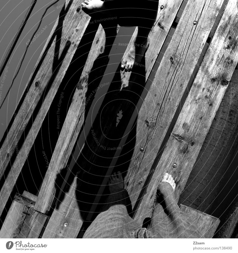 twosome Relaxation Lake Footbridge Wooden board Stand Man Masculine Leisure and hobbies Glittering Unwavering Friendship Black & white photo Water Feet Legs