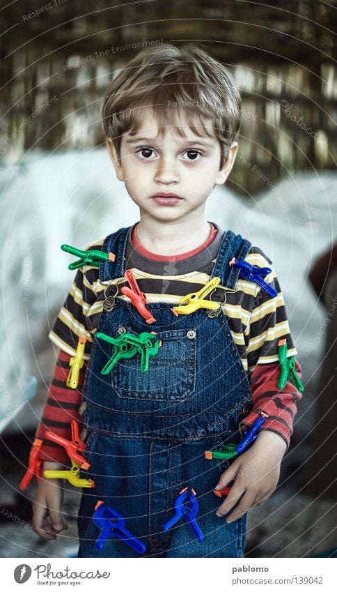 boy Child Blonde Stripe T-shirt Toddler sad sadness play playful hair blue Jeans clamp toy childhood face eyes caucasian looking serious standing cute