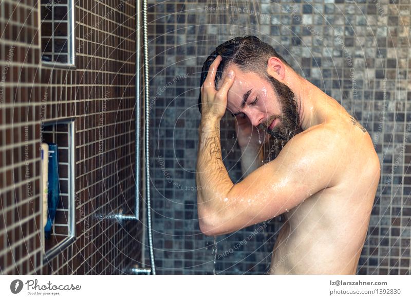 Young bearded man washing his hair Personal hygiene Health care Bathroom Man Adults Beard Hair Naked Clean bathing cleanliness closed Copy Space cubicle eyes
