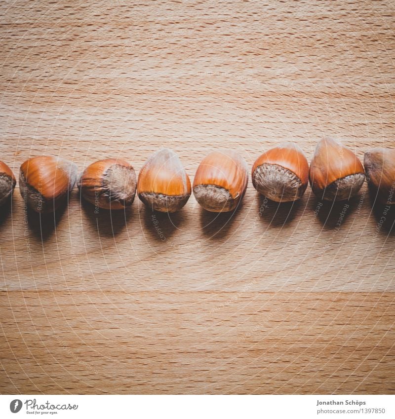 Hazelnuts on a wooden table in a row Food Nutrition To have a coffee Picnic Organic produce Vegetarian diet Slow food Finger food Esthetic Brown Hazel brown