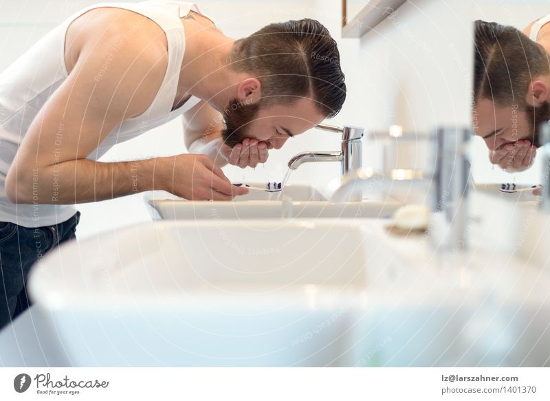 Man rinsing his toothbrush under running water Face Bathroom Adults Beard Toothbrush Clean brushing care Caucasian Copy Space faucet getting ready leaning over