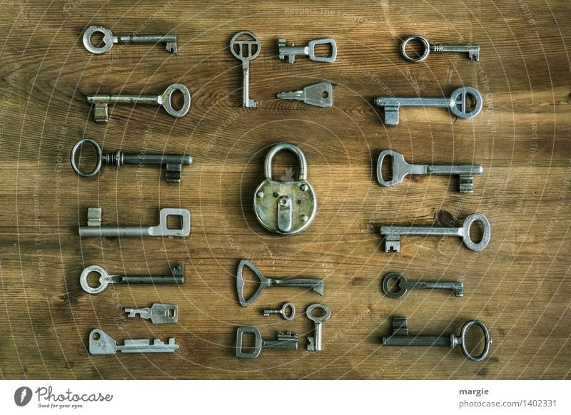 Which one fits? Many different keys are arranged around a door lock Locksmith Technology Key Padlock Collection Wood Metal Brown Black Concern Close Undo