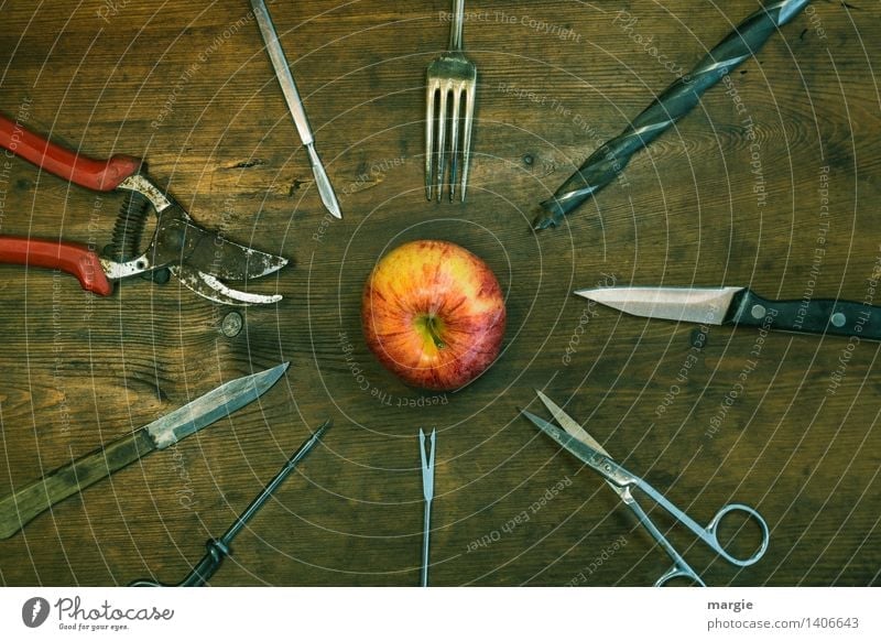 Skewers: pointed objects such as scissors, knives, forks, drills are arranged around an apple Food Fruit Apple Nutrition Knives Fork Handicraft Home improvement